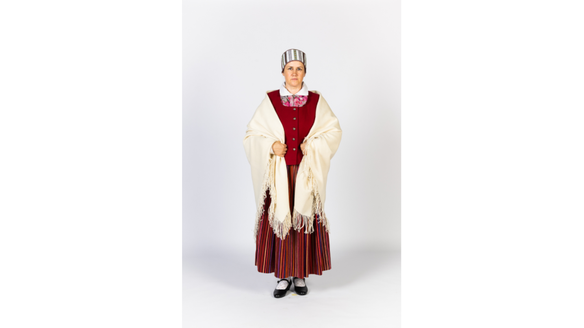 Piebalgas sievas tērps. Svītraini brunči, keklas, ņieburs, zeķes apavi, izšūta vainagveida Vidzemes sievas cepure, uz pleciem austs, balts dubults, trīsstūra formas lakats ar bārkstīm.
