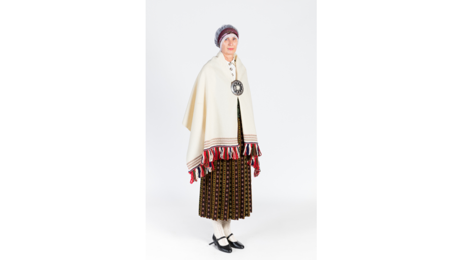 Sieva Zemgales tērpā. Balts, krekls, rozīšu burunči, zaļa auduma ņieburs, balta villaine, kas sasprausta ar lielo saktu, galvā tilla aube, kas pārsieta ar lakatiņu, kājās baltas zeķes un melnas kurpes.