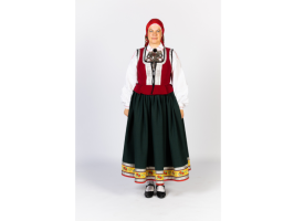 Sieviete Virgas tautastērpā. Mugurā melna auduma brunči, kuri lejasmalā rotāti ar dekoratīvām lentām, sarkans ņieburs, galvā lakats, kurš sasiets uz aizmuguri.